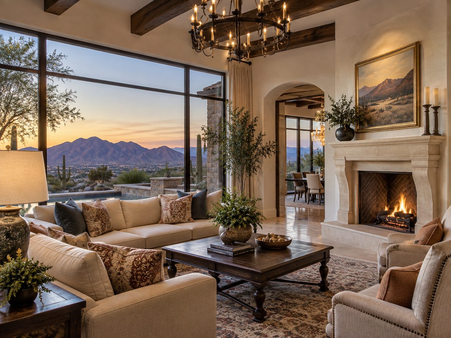 Living room with stone fireplace and desert mountain view through floor-to-ceiling windows at dusk