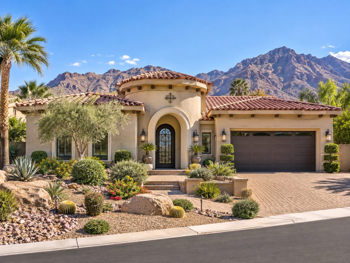 Tuscan-style desert home with tile roof, cacti landscaping, and mountains behind