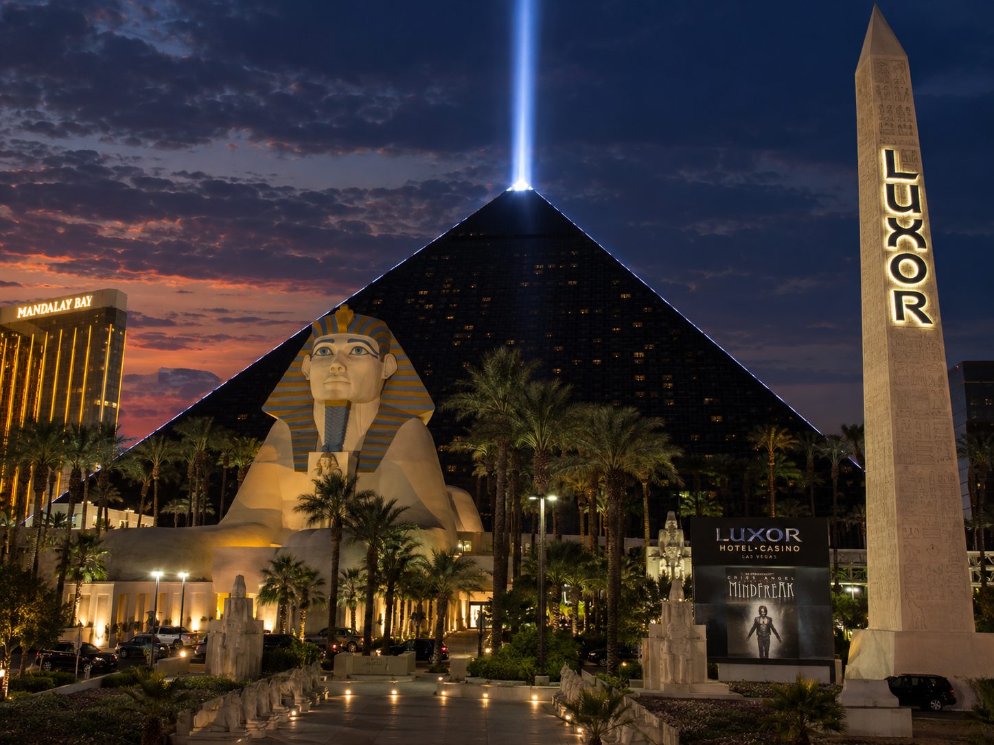 Luxor pyramid hotel with sphinx statue and light beam at dusk in Las Vegas